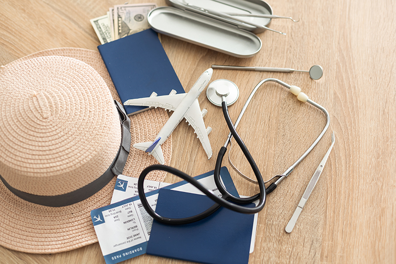Medical Tourism, medical travel concept. Stethoscope, toy plane and passport on wooden background